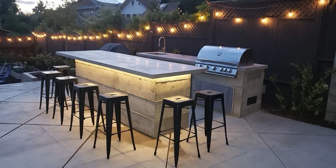 Modern outdoor kitchen and patio with stone retaining wall